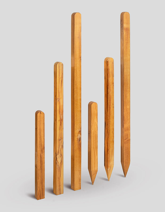 Vierkante palen, geschaafd en afgeschuind, met een halfronde bovenkant van robiniahout.